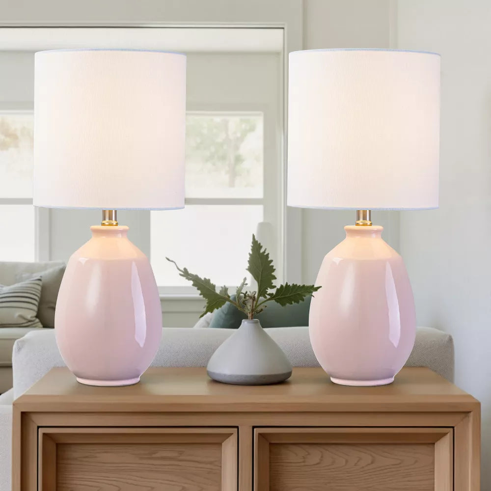 Moderne Tischlampe mit glänzender Keramikbasis und weißem Leinenzylinderschirm