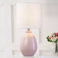 Moderne Tischlampe mit glänzender Keramikbasis und weißem Leinenzylinderschirm